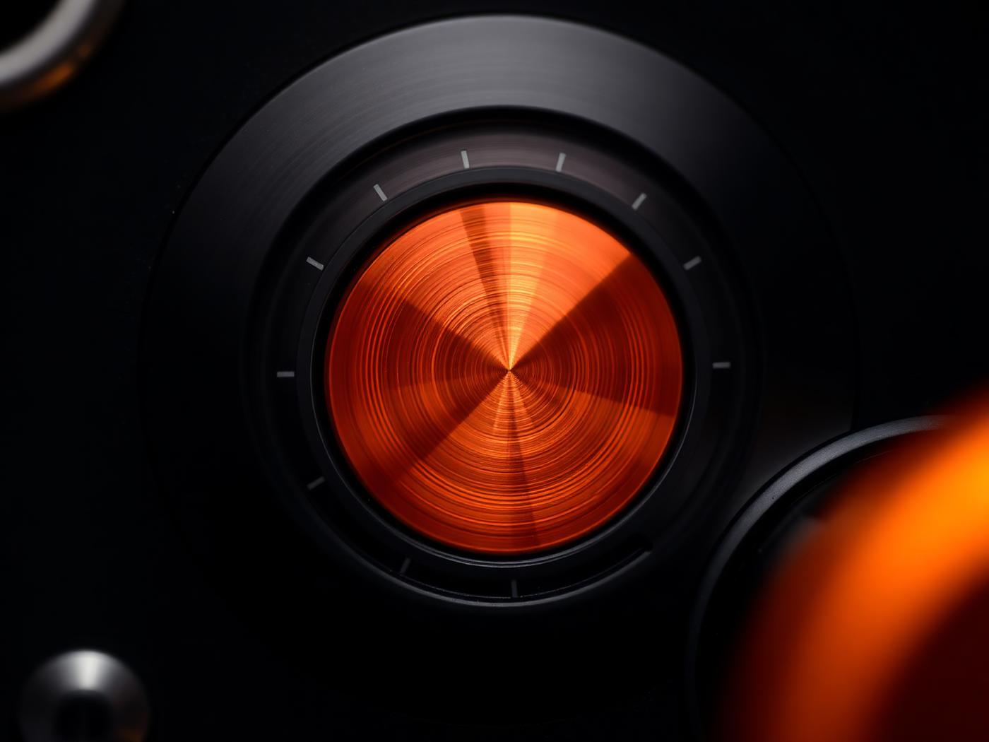 Close detail of a machined aluminium control dial with an AKOUE Orange indicator line.