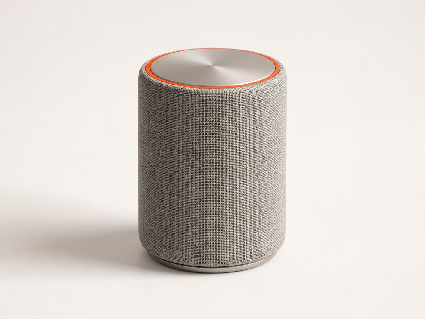 AKOUE home speaker in pearl-silver aluminium with a dark acoustic grille and a subtle AKOUE Orange base detail.